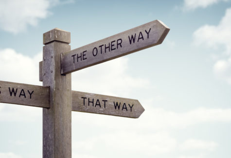 A wooden signpost that mark 'This Way', 'That Way', and 'The Other Way'.