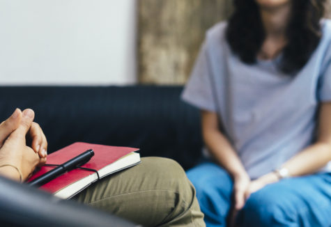 A female sitting on a couch across from an interviewer.