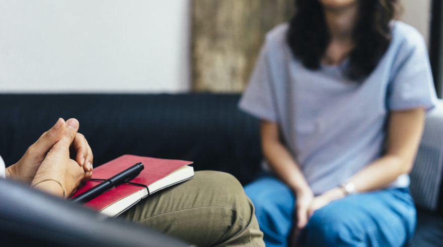 A female sitting on a couch across from an interviewer.