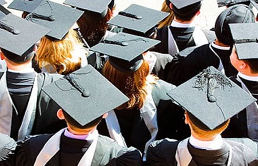 students lined up for high-school graduation in their cap and gown.