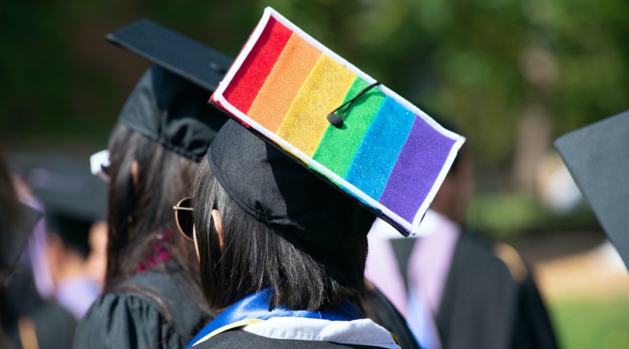 A graduating senior with the LGBTQ flag on her graduation cap.